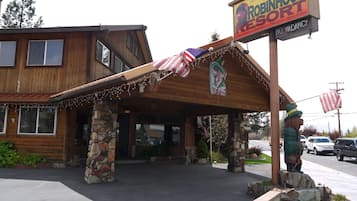 A wooden building with a sign for Robinhood Resort, featuring stone pillars and a covered entrance.