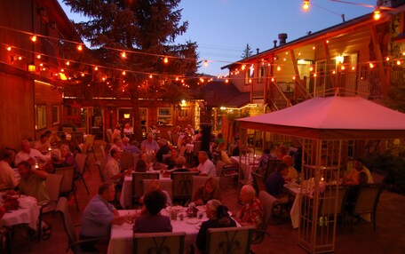 An outdoor dining area with string lights, tables, and chairs.
