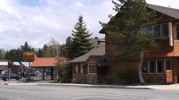 A building with a stone facade, large windows, and a sign for a restaurant.