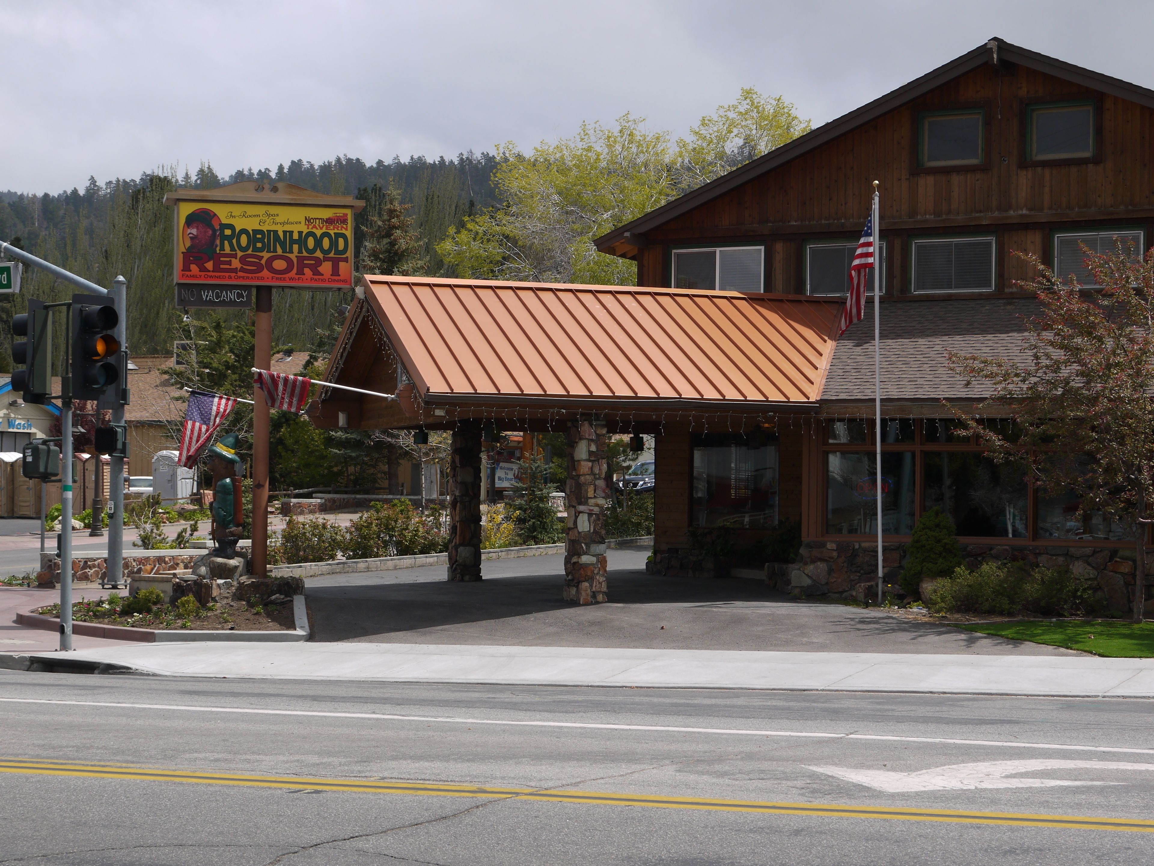 A wooden building with a metal roof and an American flag.