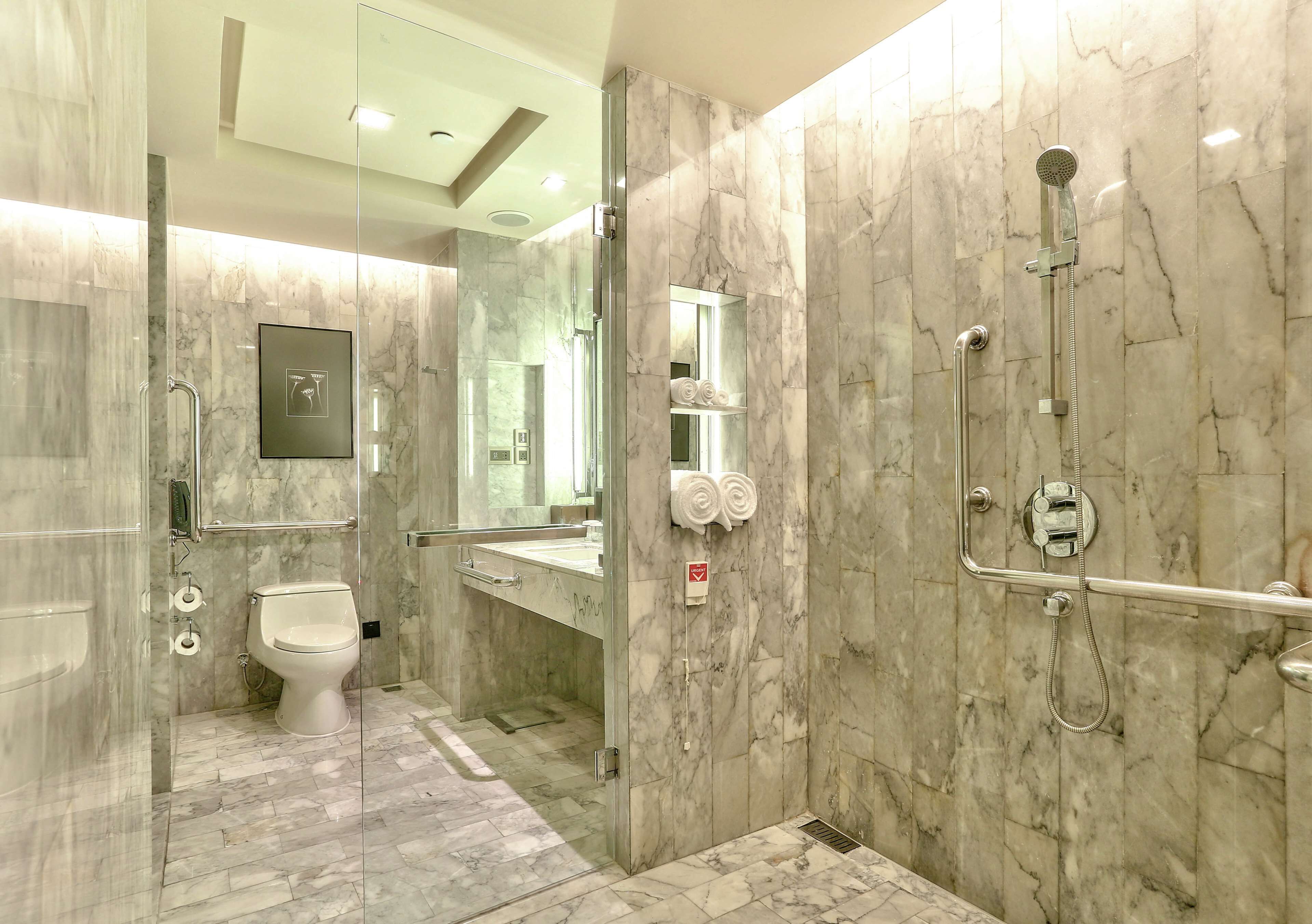 A modern bathroom with a glass-enclosed shower, a toilet, and a vanity with a mirror.