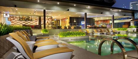 Alberca al aire libre y camastros