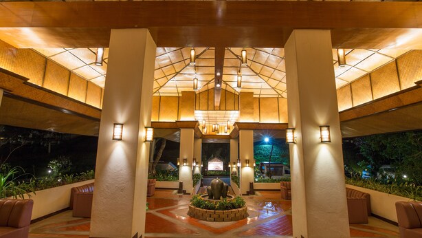 Eine geräumige Lobby mit hoher Decke, einem zentralen Brunnen und Sitzbereichen.