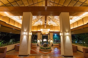 A spacious lobby with a high ceiling, central fountain, and seating areas.
