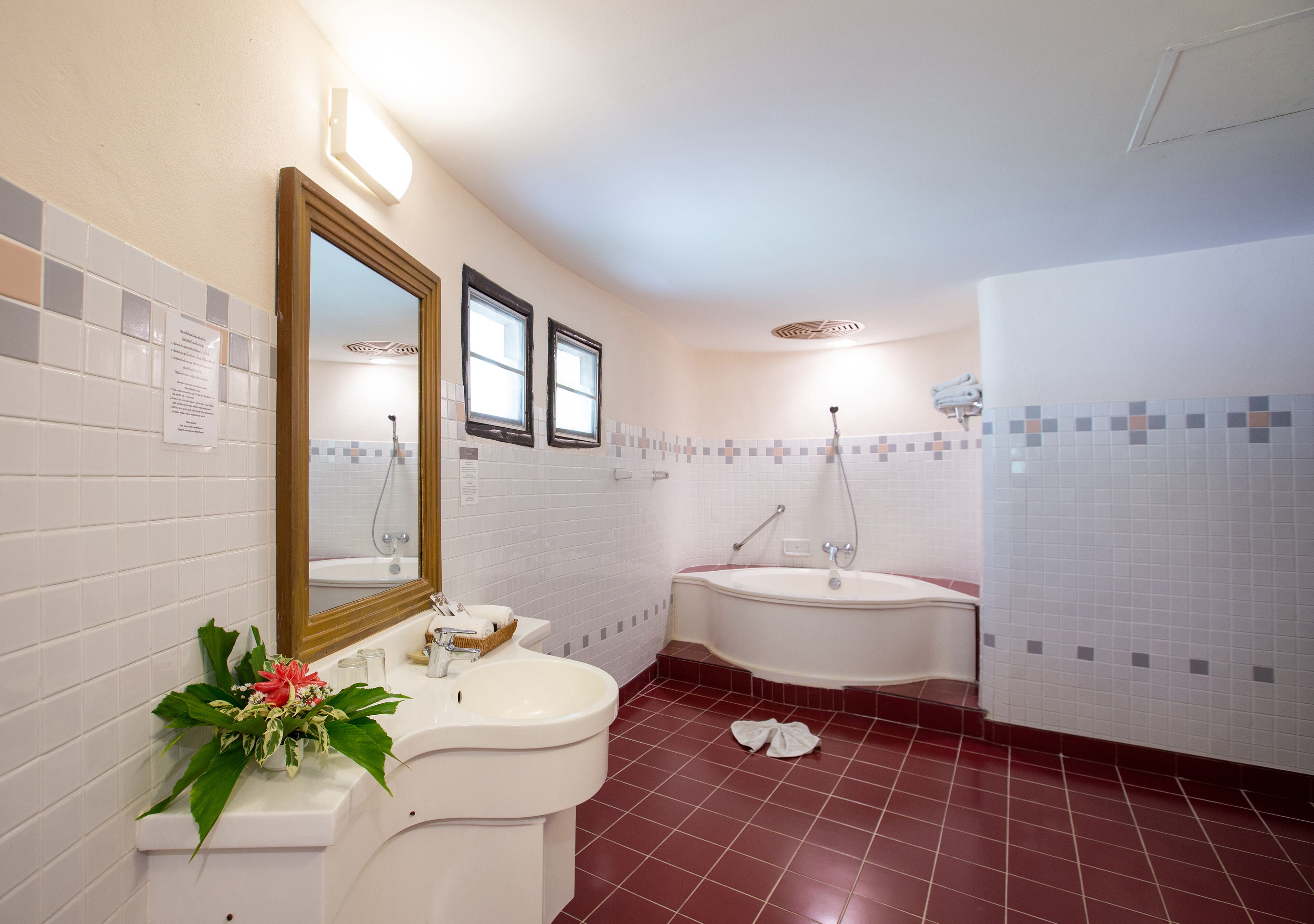 Een badkamer met een wastafel, spiegel en bad.
