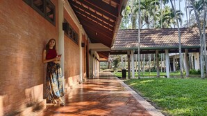 A covered walkway with a tiled floor, a brick wall, and a covered area with a tiled roof. - The Imperial Chiang Mai Resort & Sports Club (Mae Rim)