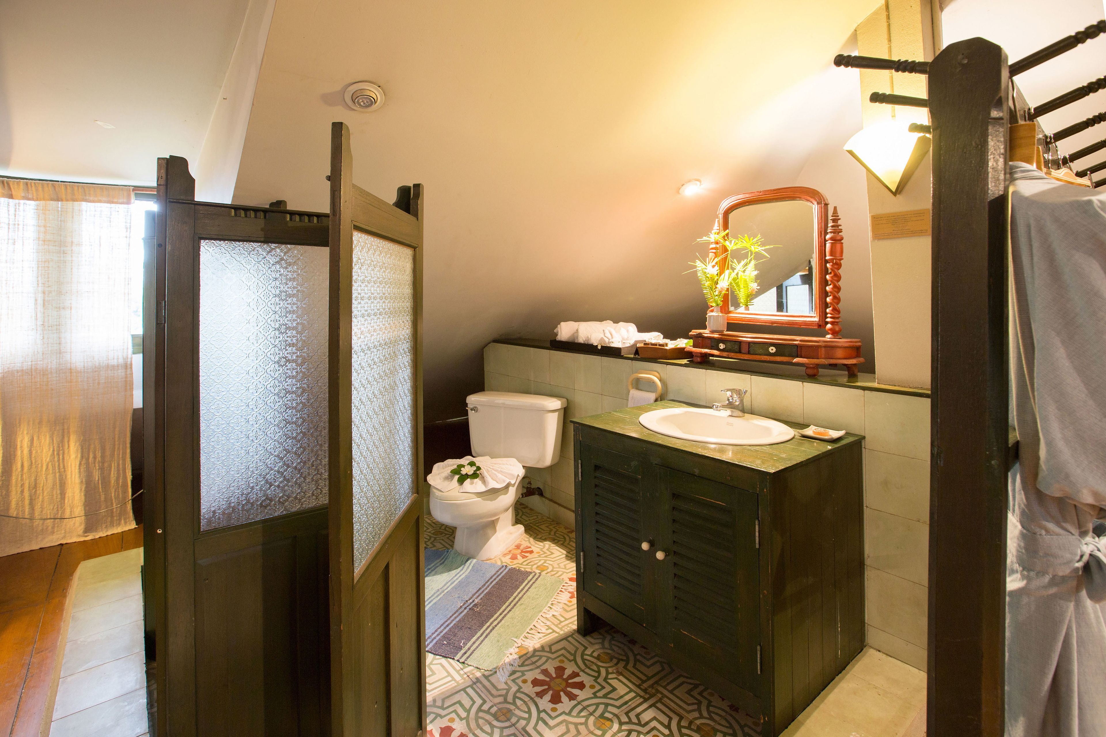 Een badkamer met toilet, wastafel en spiegel.
