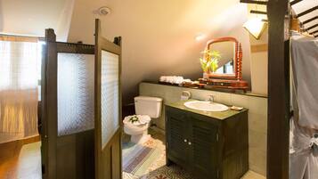 Een badkamer met toilet, wastafel en spiegel.