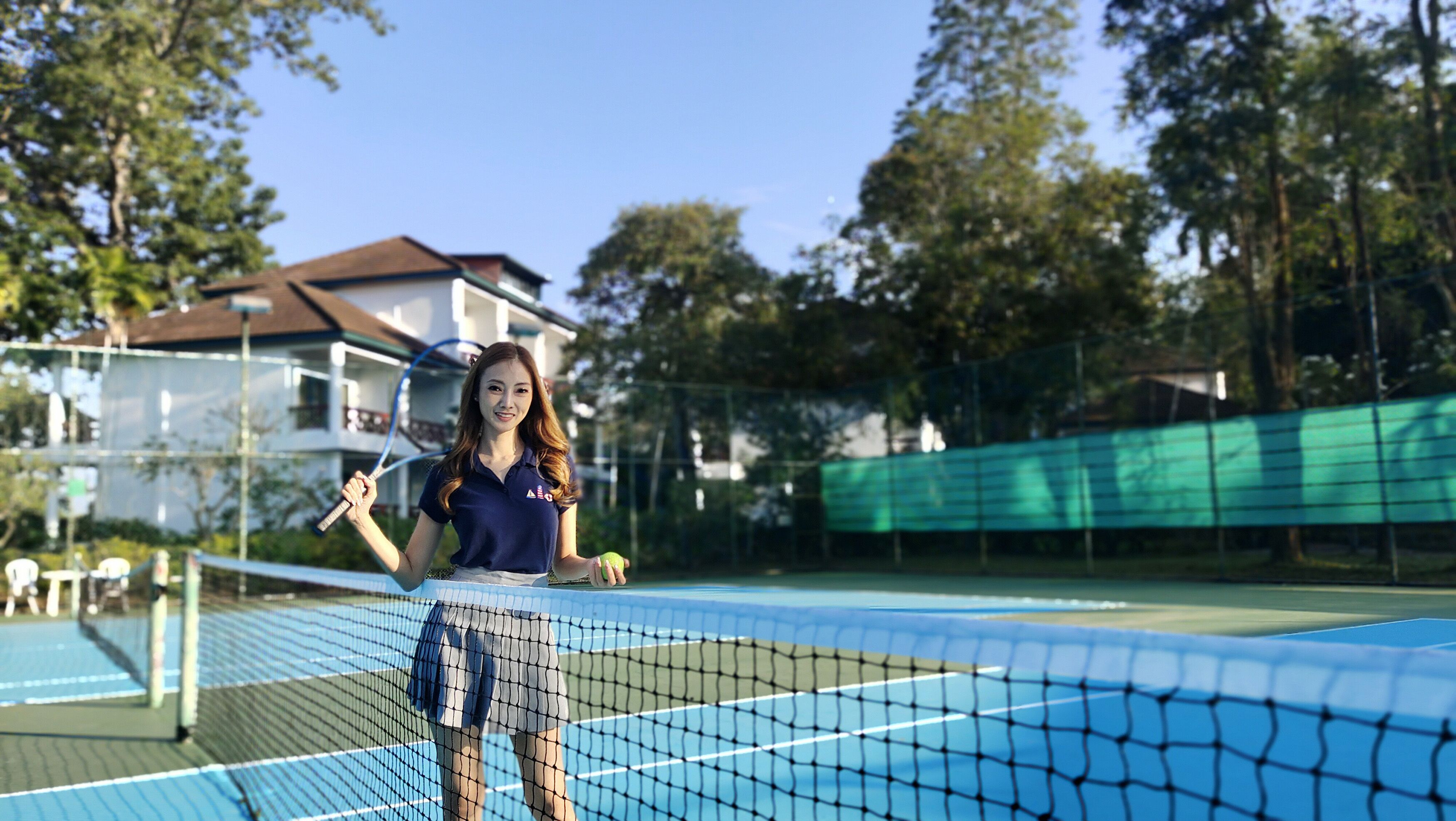 Ein Tennisplatz mit Netz, Tennisschläger und Tennisball.