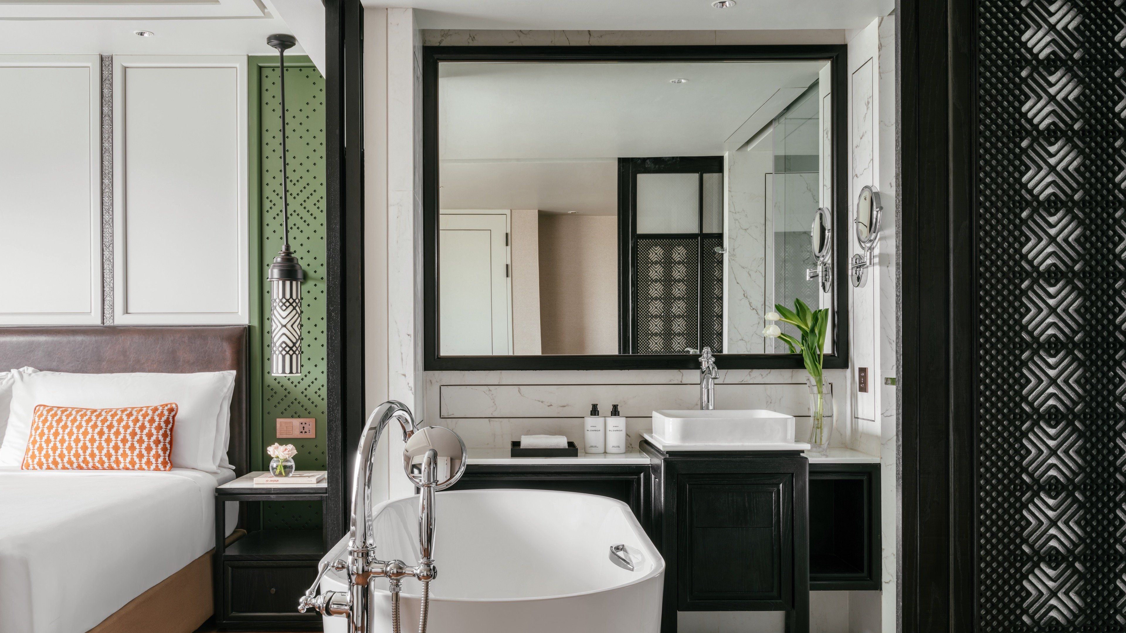 A modern bathroom with a freestanding bathtub, a large mirror, and a vanity with a sink.