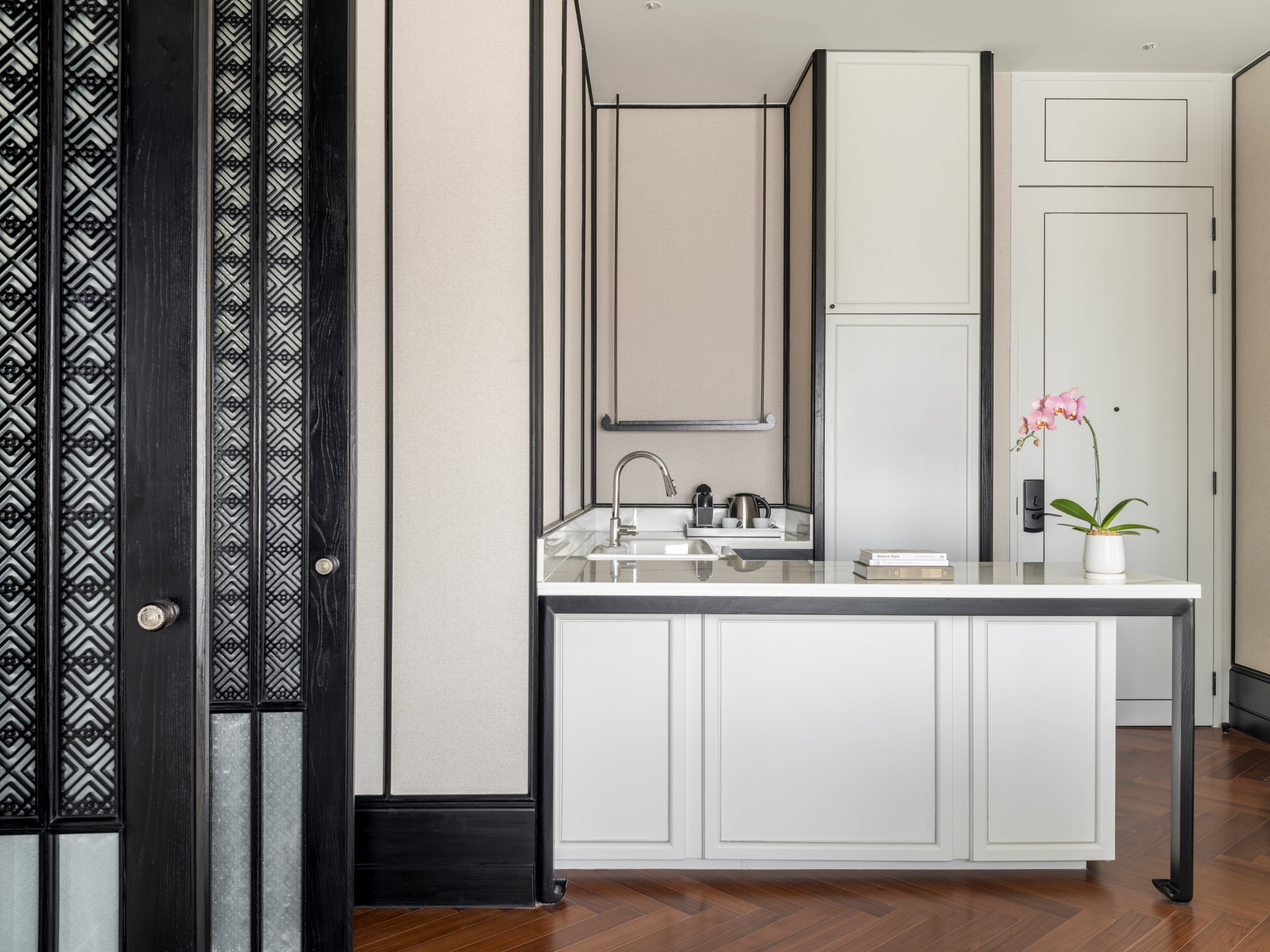 A modern bathroom with a white vanity, a mirror, and a sink.