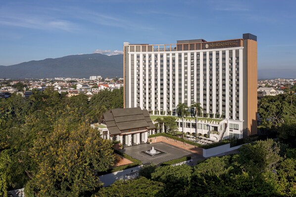 Un grand hôtel moderne doté d’une cour intérieure et d’une fontaine.