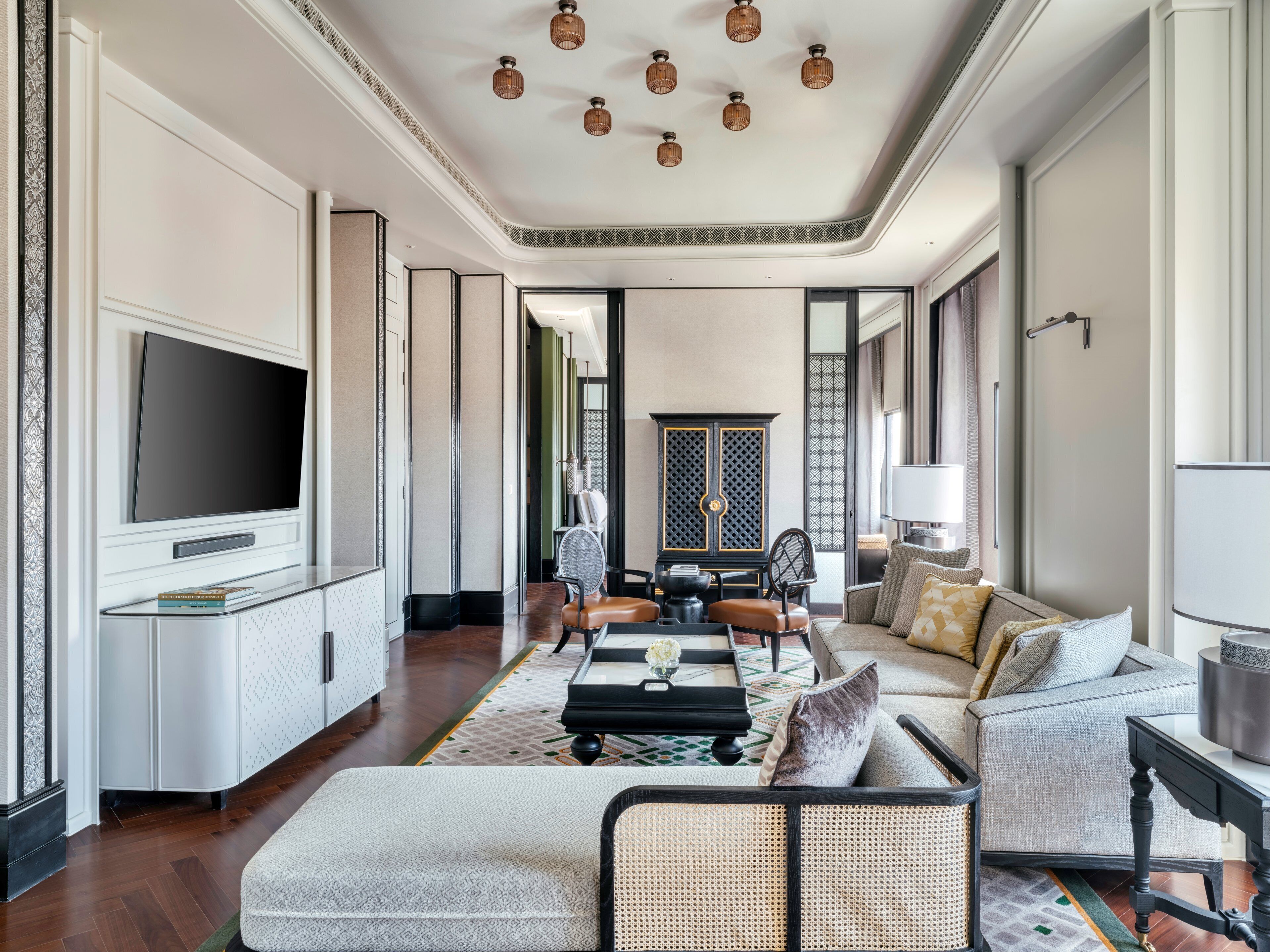 Amplia sala de estar con televisor de pantalla plana, asientos cómodos y un aparador decorativo.