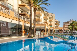 Una piscina al aire libre, sombrillas, tumbonas