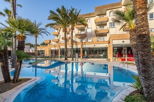 Una piscina al aire libre, sombrillas, tumbonas