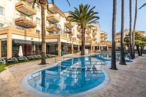 Una piscina al aire libre, sombrillas, tumbonas