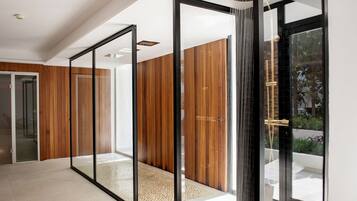 Un interior moderno con puertas de cristal correderas, paneles de madera y suelo de baldosas.