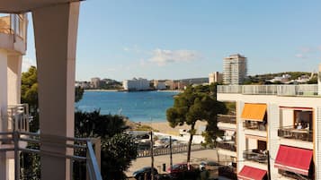 Vista costera con edificios, un puerto deportivo y cielo despejado.