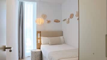 Un dormitorio con cama, mesita de noche, lámpara y decoración en la pared.