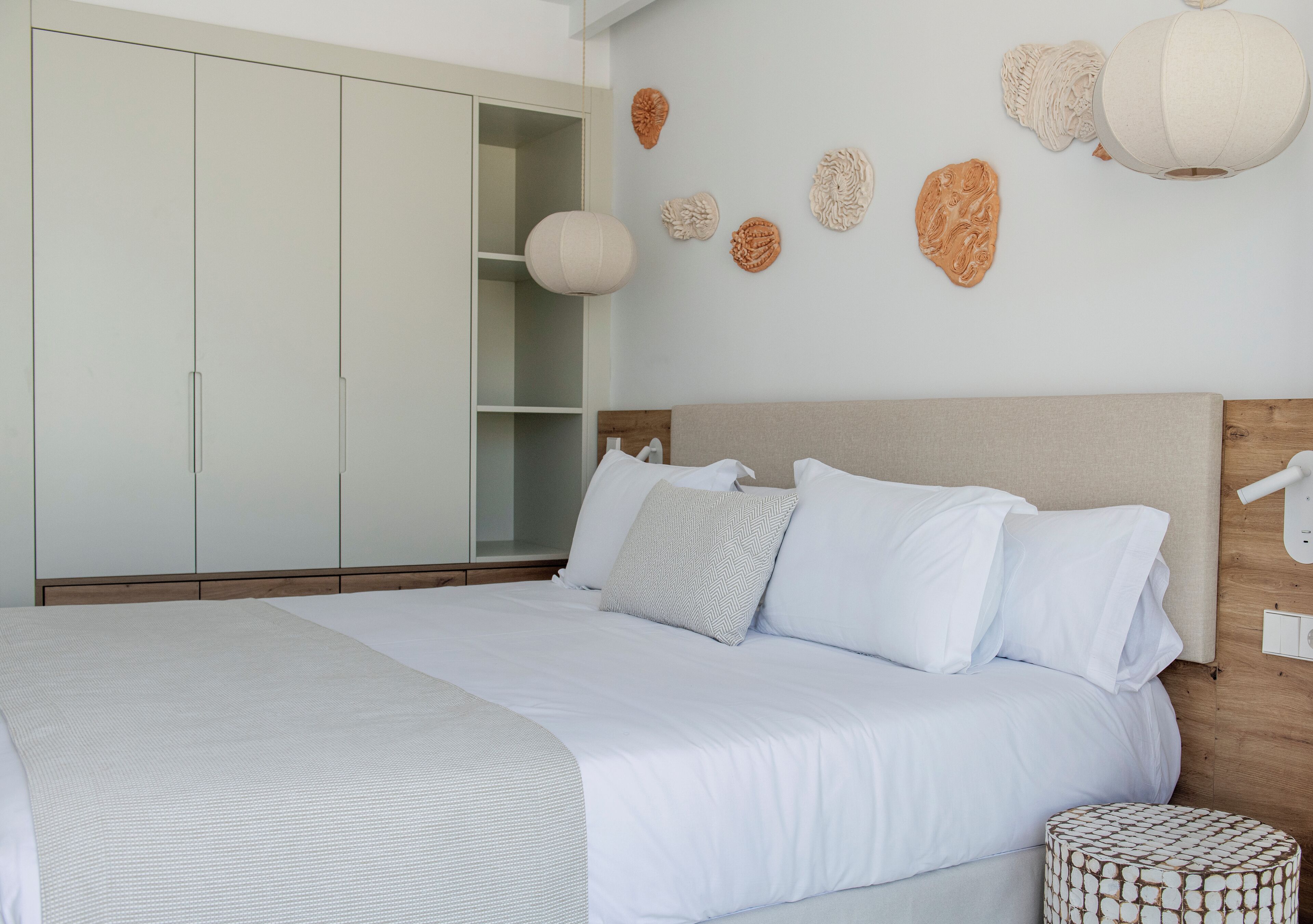 Un dormitorio con una cama grande, un armario y decoración en la pared.