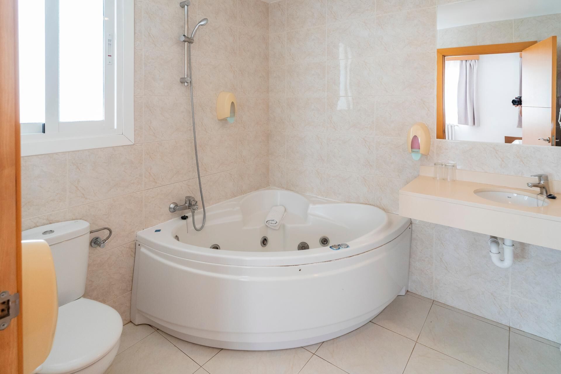 Un baño moderno con una bañera independiente, un inodoro y un lavabo con espejo.