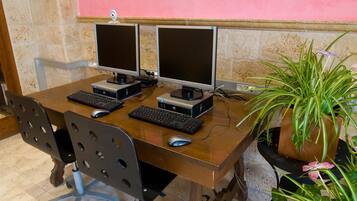 A wooden desk with two computer monitors, keyboards, and mice.