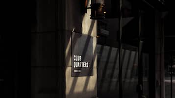 A sign for 'CLUB QUARTERS' on a building facade with a modern design.