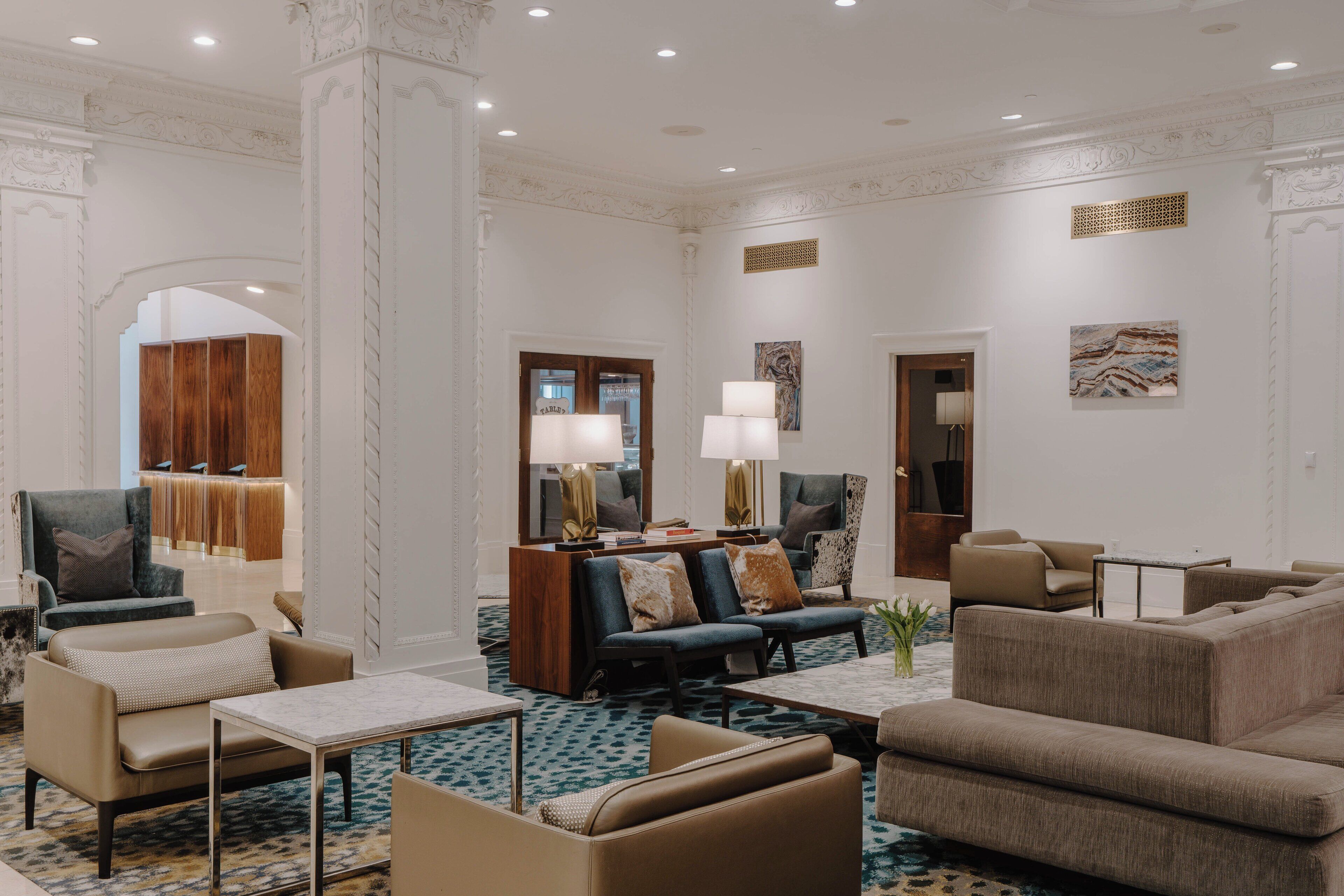 Un hall d’entrée spacieux avec un coin salon moderne, un comptoir d’accueil et un mur décoratif.