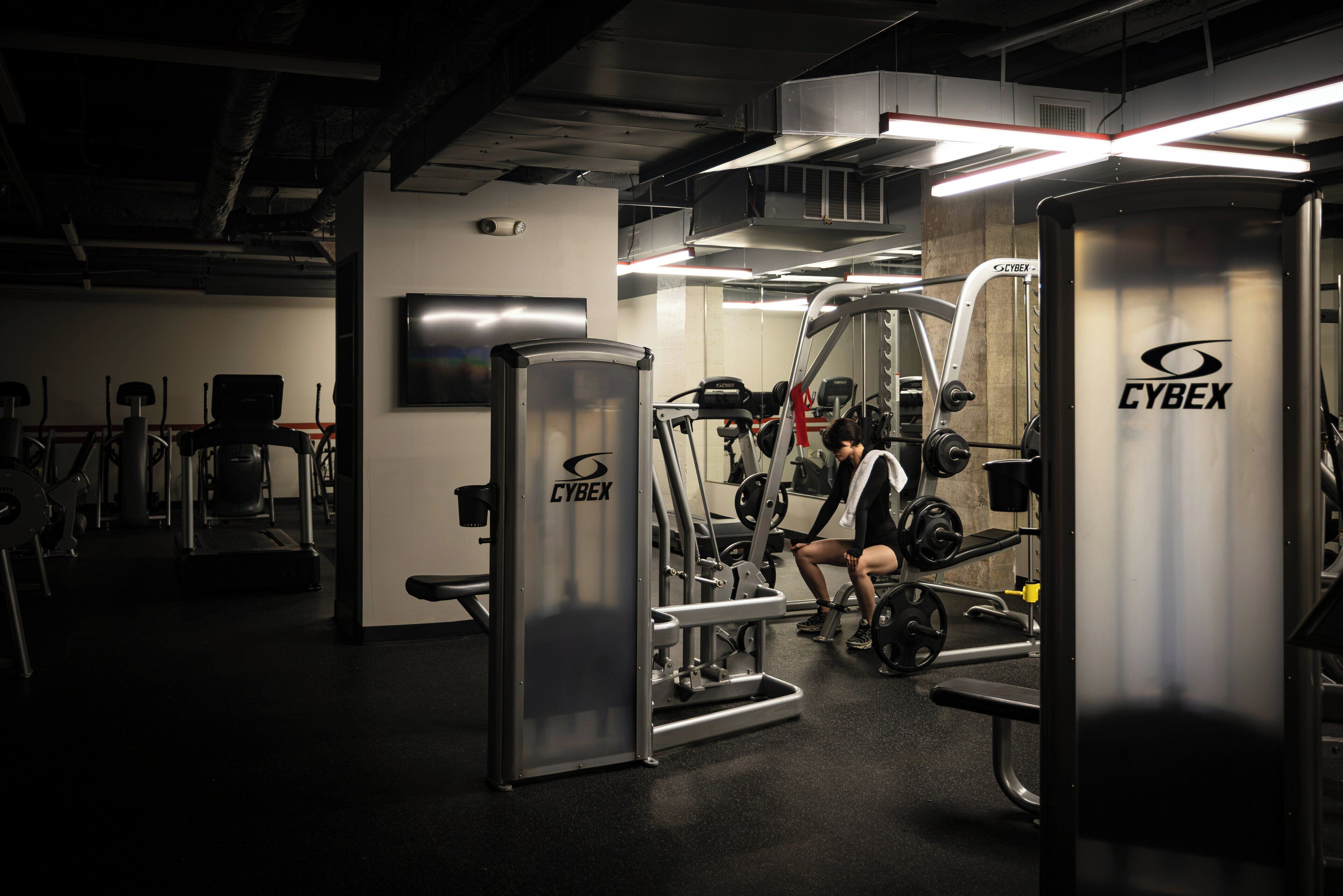 Une salle de sport équipée de machines Cybex, d’un téléviseur et d’un miroir.