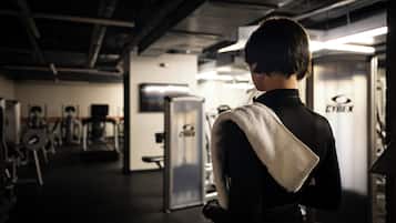 Un gimnasio con equipo de ejercicio y una persona con una toalla.