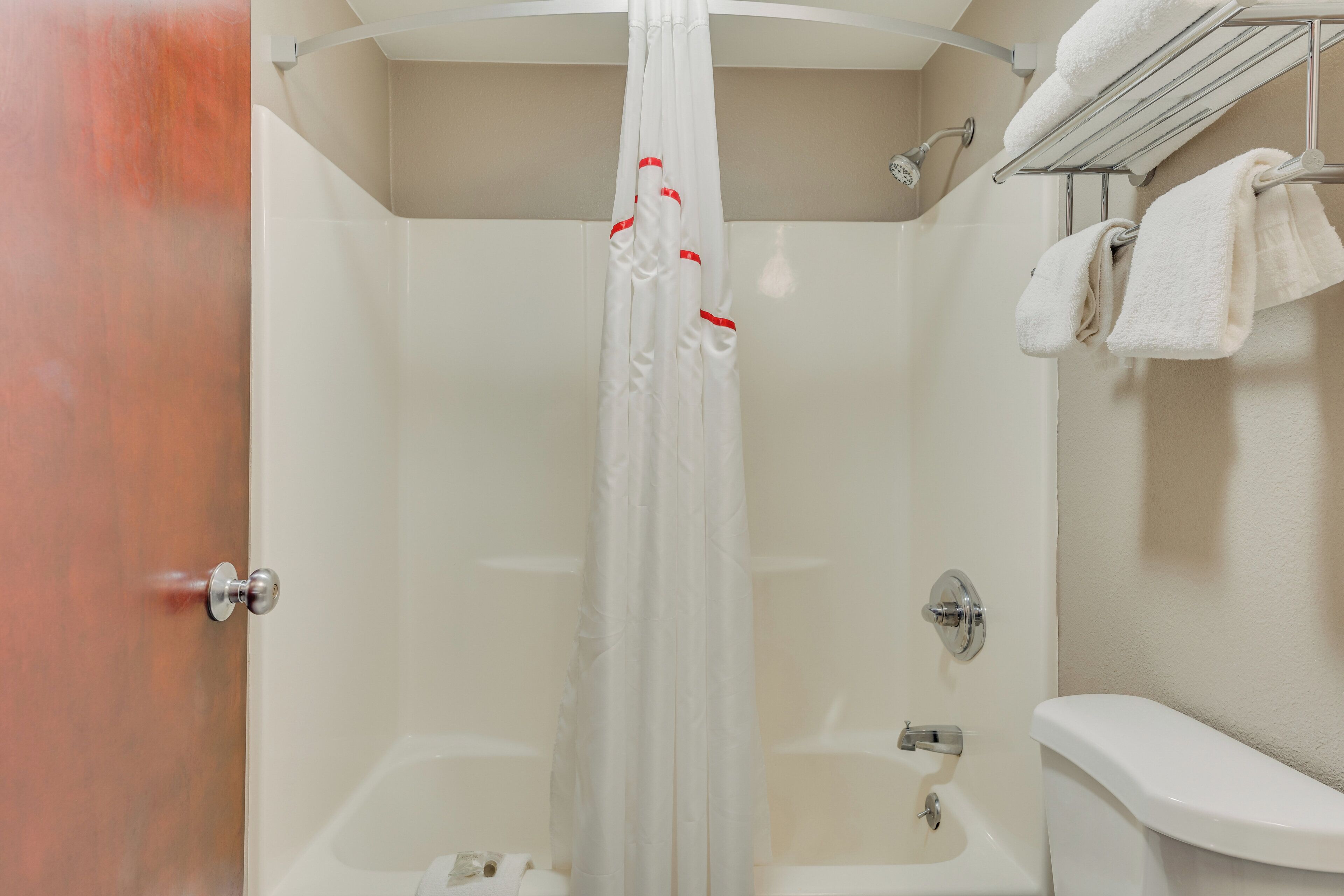 Une salle de bain avec une douche, des toilettes et un porte-serviettes.