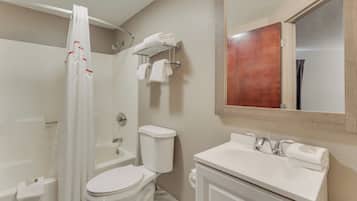 Een badkamer met een bad, toilet en wastafel.