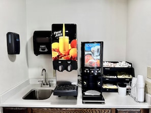 A self-service beverage station with options for fruit juice, iced coffee, hot water, and decaf coffee. - Red Roof Inn & Suites Newport – Middletown, RI (Middletown)