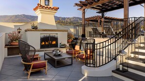 A rooftop patio with a fireplace, outdoor seating, and a pergola. - Kimpton Canary Hotel by IHG (Santa Barbara)