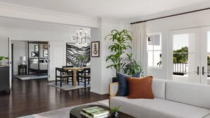 A modern living room with a sofa, coffee table, and a dining area with a table and chairs. - Kimpton Canary Hotel by IHG (Santa Barbara)