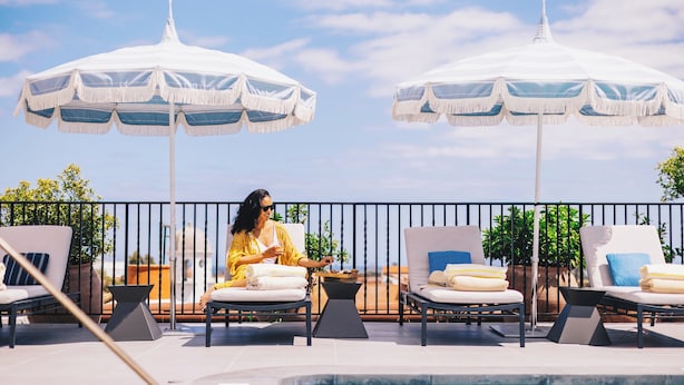 A rooftop terrace with outdoor seating, umbrellas, and a pool. - Kimpton Canary Hotel by IHG (Santa Barbara)