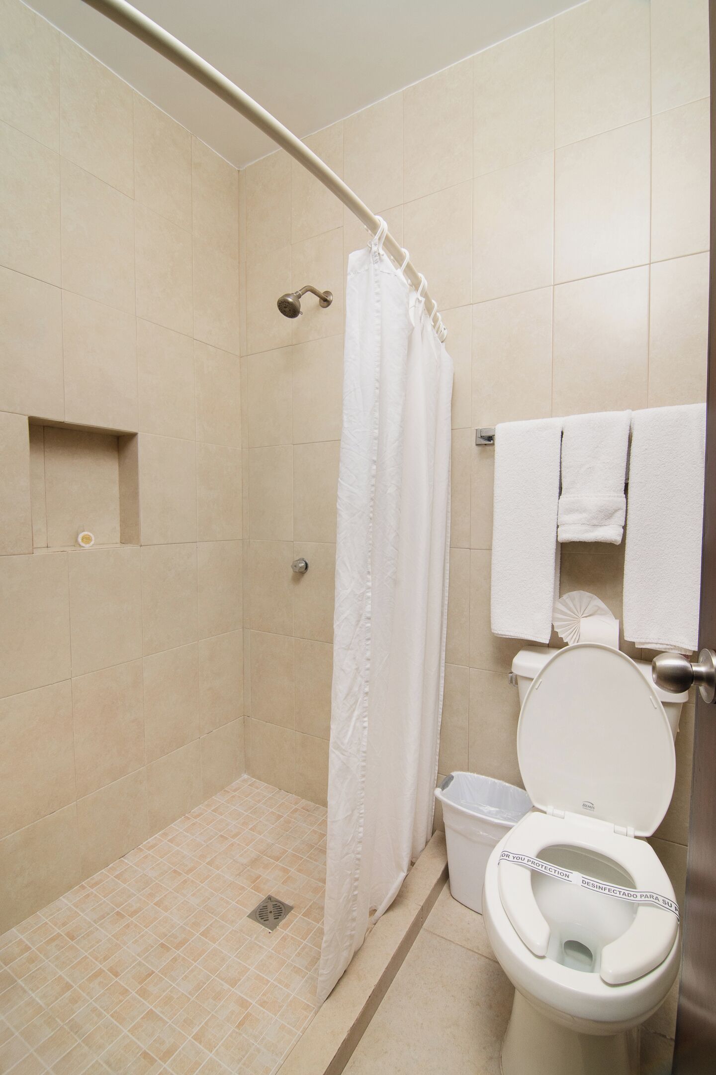 Un baño con ducha, inodoro y un perchero para toallas.
