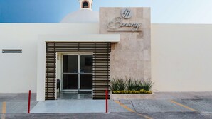 A modern building with a sign reading "Banana Restaurant-Bar" and a dome-shaped structure in the background. - Best Western Plus San Jorge (Cajeme)