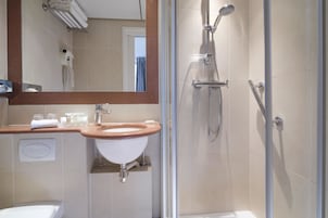 A bathroom with a sink, mirror, towel rack, and shower.