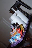 A tray with various items including a white mug, a black coffee maker, and several food packages.
