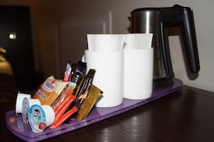 Ett bricka med kaffekoppar, en kaffebryggare och olika sorters matvaror, som till exempel snacks och tillbehör.