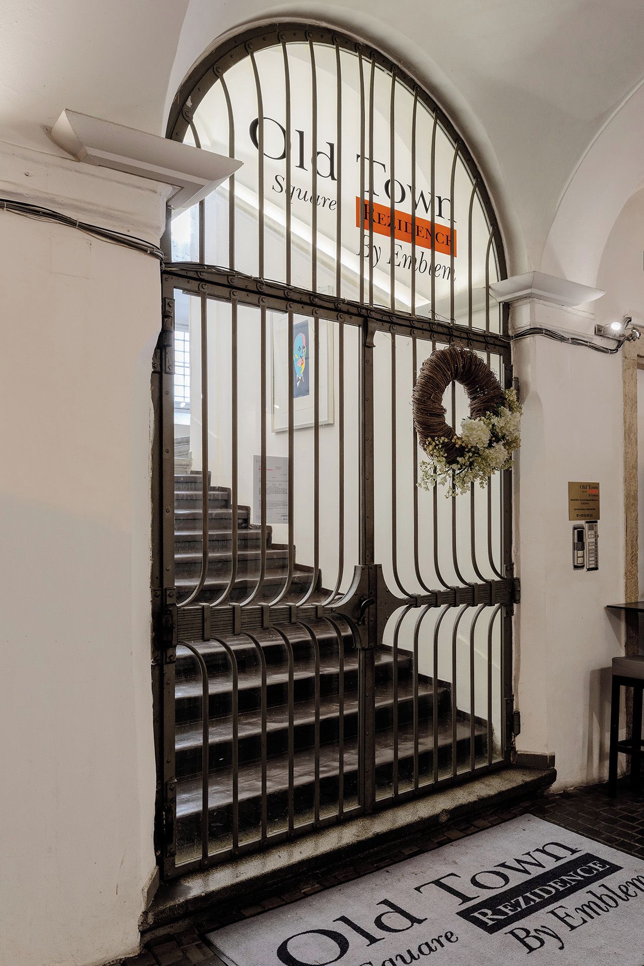 A wrought iron gate with a sign reading 'Old Town Residence By Emblem.'