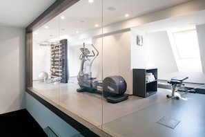 A modern gym with exercise equipment, a treadmill, and a stationary bike. - Old Town Square Residence by Emblem (Prague)