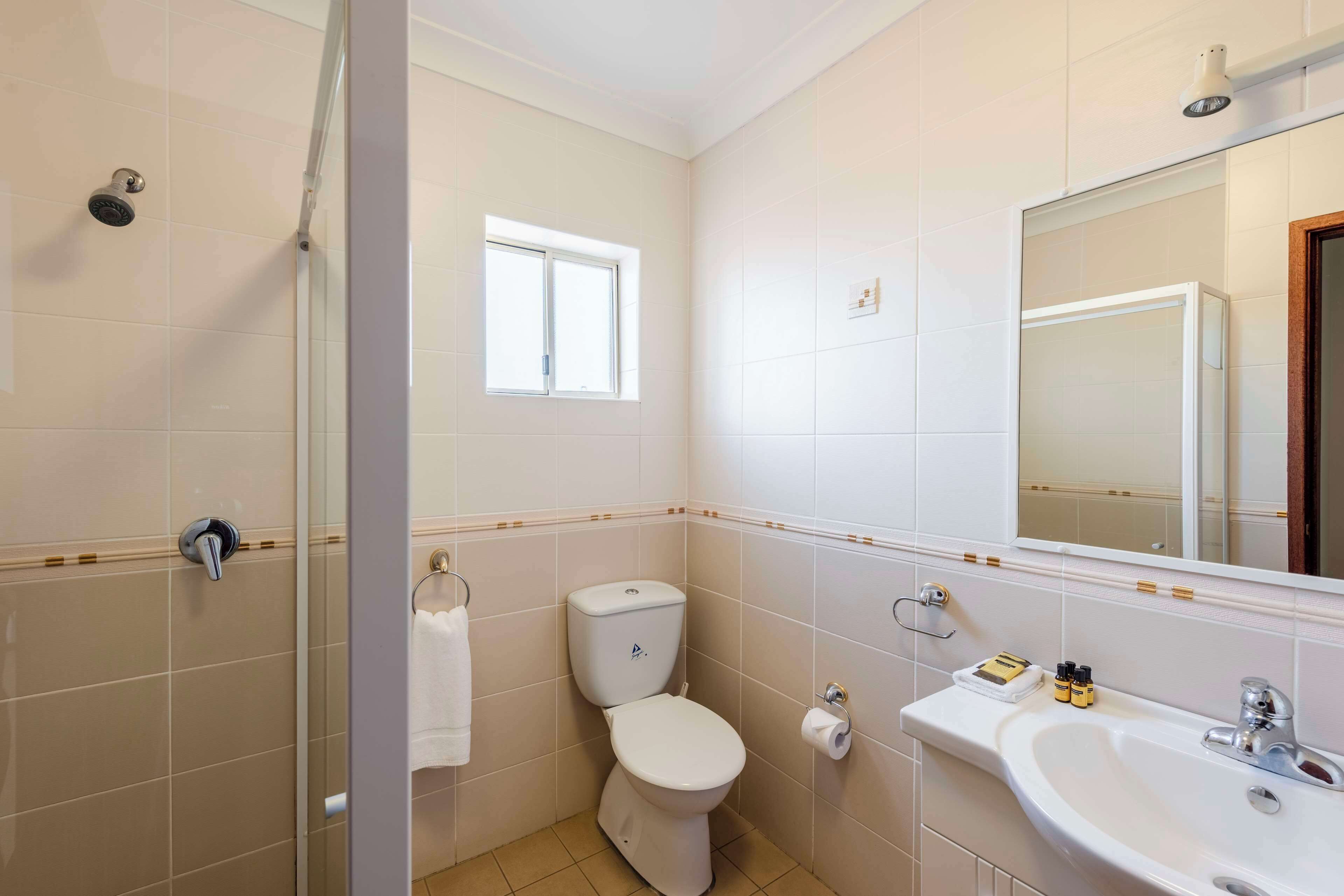 A bathroom with a toilet, sink, and shower.