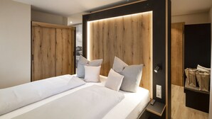 Een moderne slaapkamer met een groot bed, een houten hoofdbord en een inbouwkast.