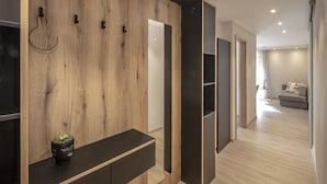 Een modern interieur met een wand van hout, een zwarte console tafel en een grijze bank in een goed verlichte kamer.