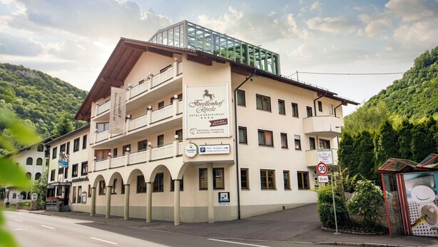 Een hotel met een bord waarop staat 'Forellenhof Rosslernt Hotel Restaurant'.