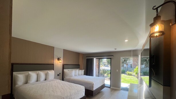A hotel room with two beds, a large window, and a flat-screen TV. - Lamp Liter Inn Visalia, an Ascend Collection Hotel (Visalia)