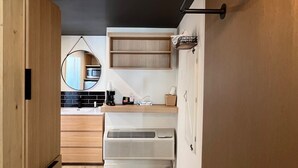 A modern kitchen with wooden cabinets, a white countertop, and a built-in microwave. - Lamp Liter Inn Visalia, an Ascend Collection Hotel (Visalia)