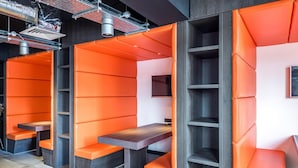 A modern interior with orange seating areas and dark wood accents. - KM Hotel (Edinburgh)